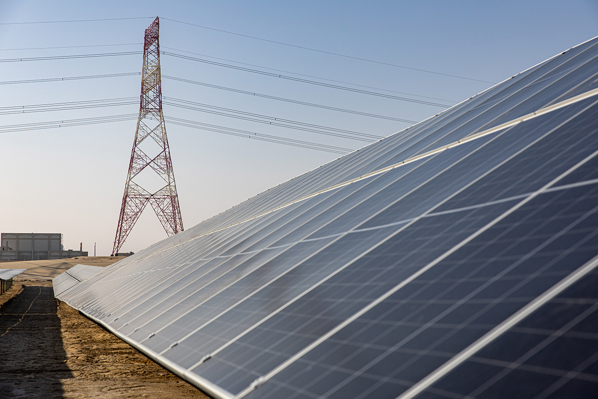 Photo above: An electricity transmission tower beyond photovoltaic panels at the al-Dhafra solar project, constructed by Electricite de France and Jinko Power Technology Co., in Abu Dhabi on January 31, 2023. Photo by Christopher Pike/Bloomberg via Getty Images.